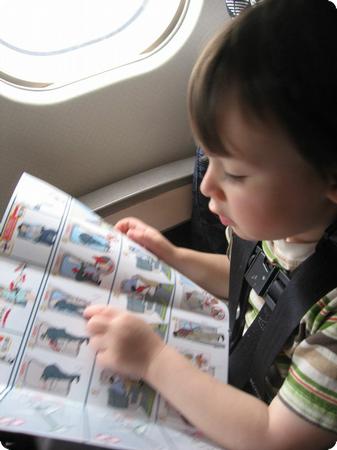 Toddler reading the Airplane Safety Manual