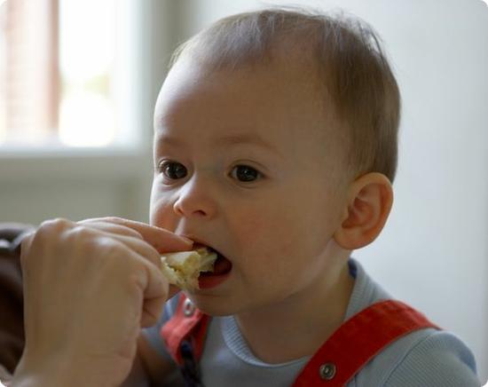 E taking a tentative bite of a mozzarella and tomato sandwich (he loved it)