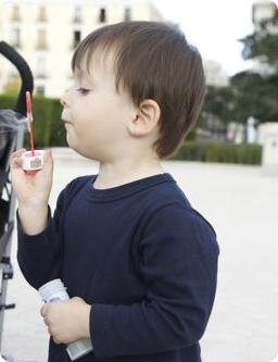 E blows bubbles at a park in Barcelona, Spain