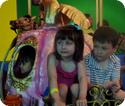 Everest and Karissa ride on a carousel in San Juan's Museo Histórico de la Biblia