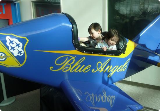 Everest and Darya pretend to be Blue Angels Pilots at Seattle's Boeing Museum of Flight