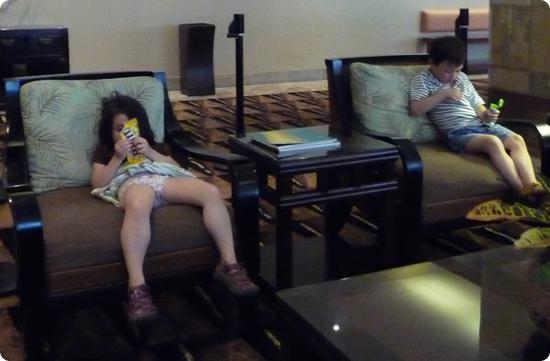 The kids relax in the lobby of the Embassy Suites Waikiki Beach Walk