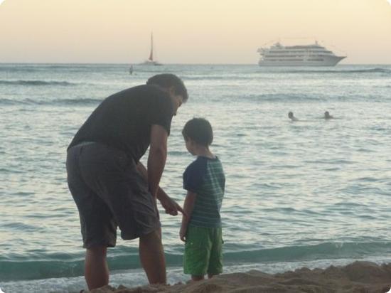 Father and Son enjoy the sunset on Waikiki Beach