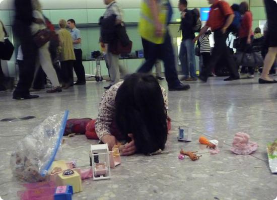 Darya spreads out her toys and plays in Heathrow's Baggage Claim Area