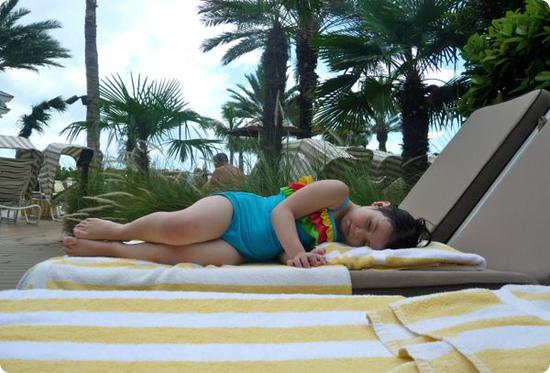 Darya rests on chaise in our poolside cabana at the Sandpearl Resort