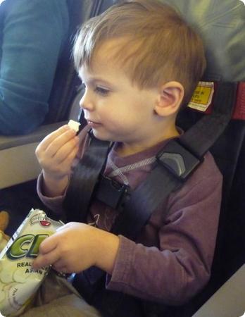 Eilan sits safely in his own airplane seat using the CARES harness