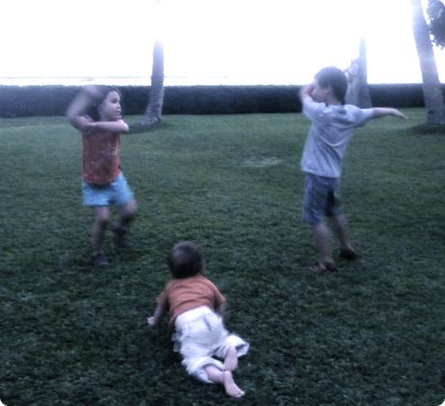 Eilan, Everest and Darya practice their hula moves on a lawn overlooking Waikiki Beach