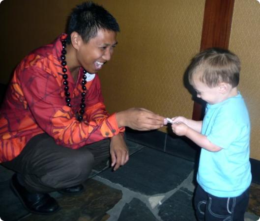 A cast member takes a moment to hand Eilan a Mickey Mouse sticker