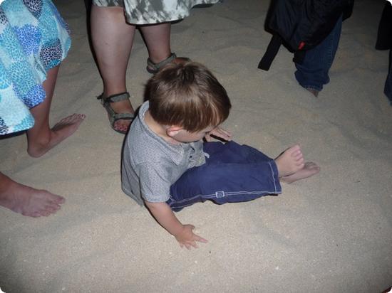 Eilan plays in the sand, oblivious to the crowds massed around him