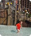 Eilan runs through the shallow water under the Menehune Bridge at Aulani Resort