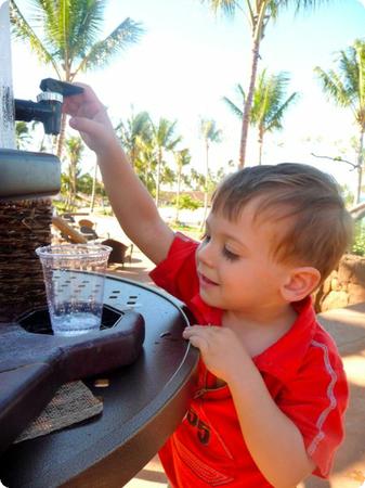 Eilan helps himself to a cup of water at a poolside water station at Aulani Resort