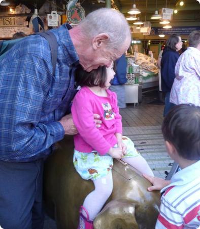 Darya needs some help staying seated on the Pig at Pike Place Market