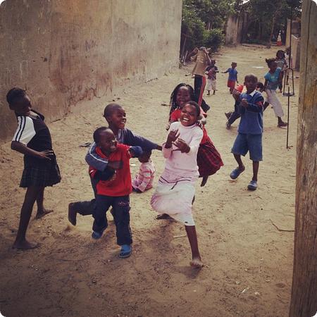 Kids stop playing to yell hello and pose for my camera as we walk by