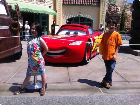 Darya and Everest pose in front of Lightning McQueen at Carsland